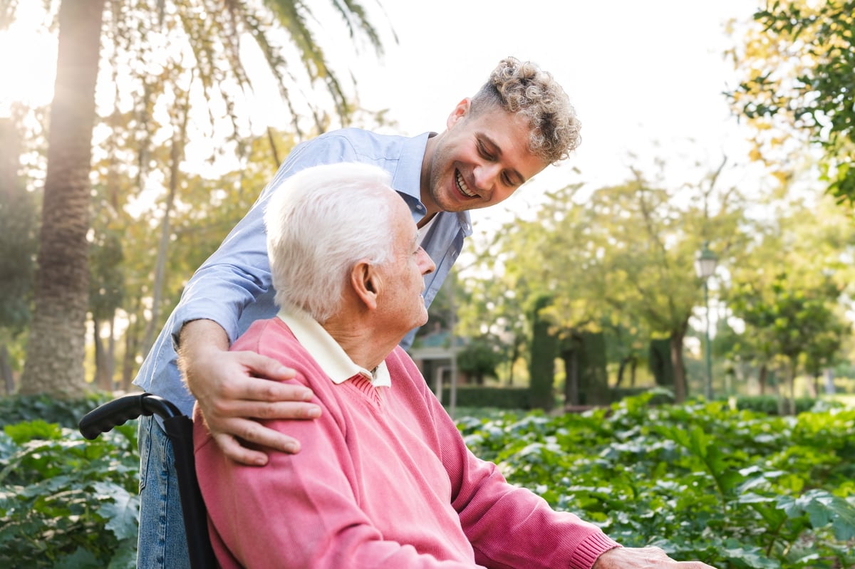 A volunteer caring for an elderly patient in a wheelchair