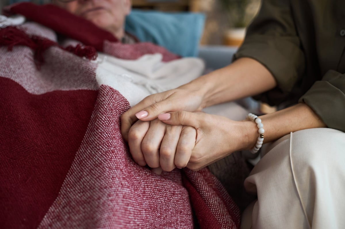 Woman holding the hand of a senior man, showing care and compassion